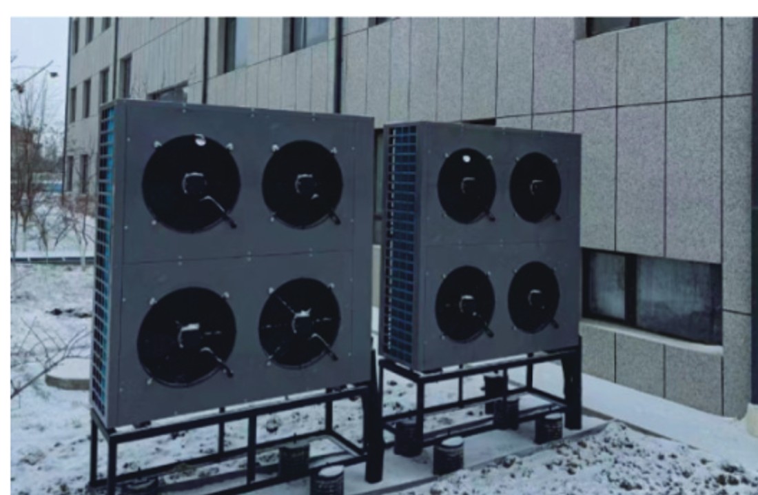 Two Snowfairy outdoor units installed on stands beside a commercial building in a snowy setting